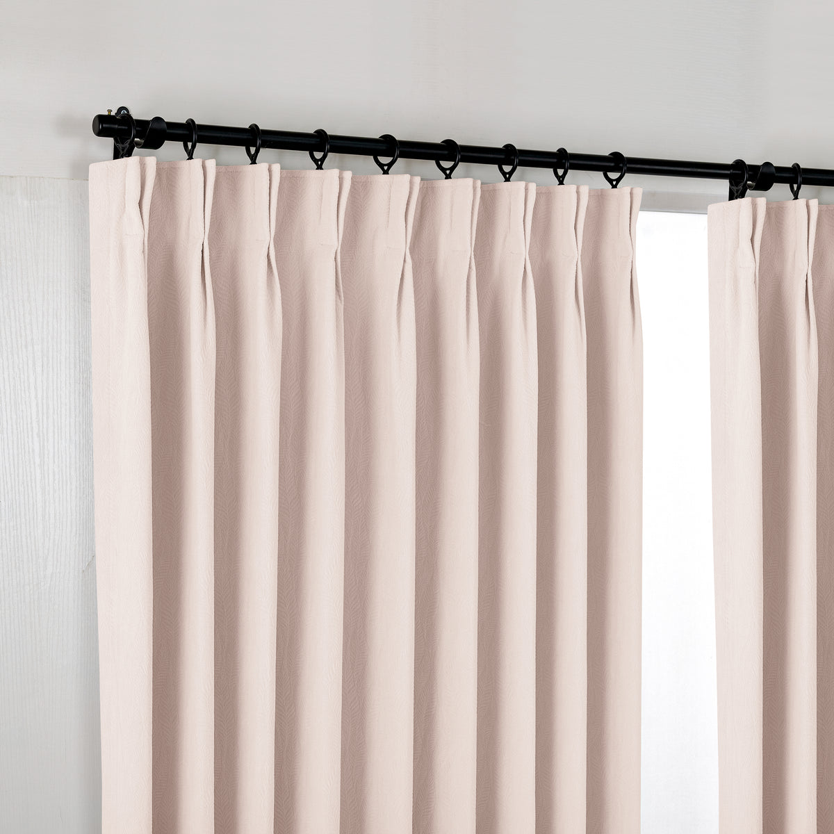 Cordelia Sculpted Chenille Blackout Curtains in Blush, hanging at the window