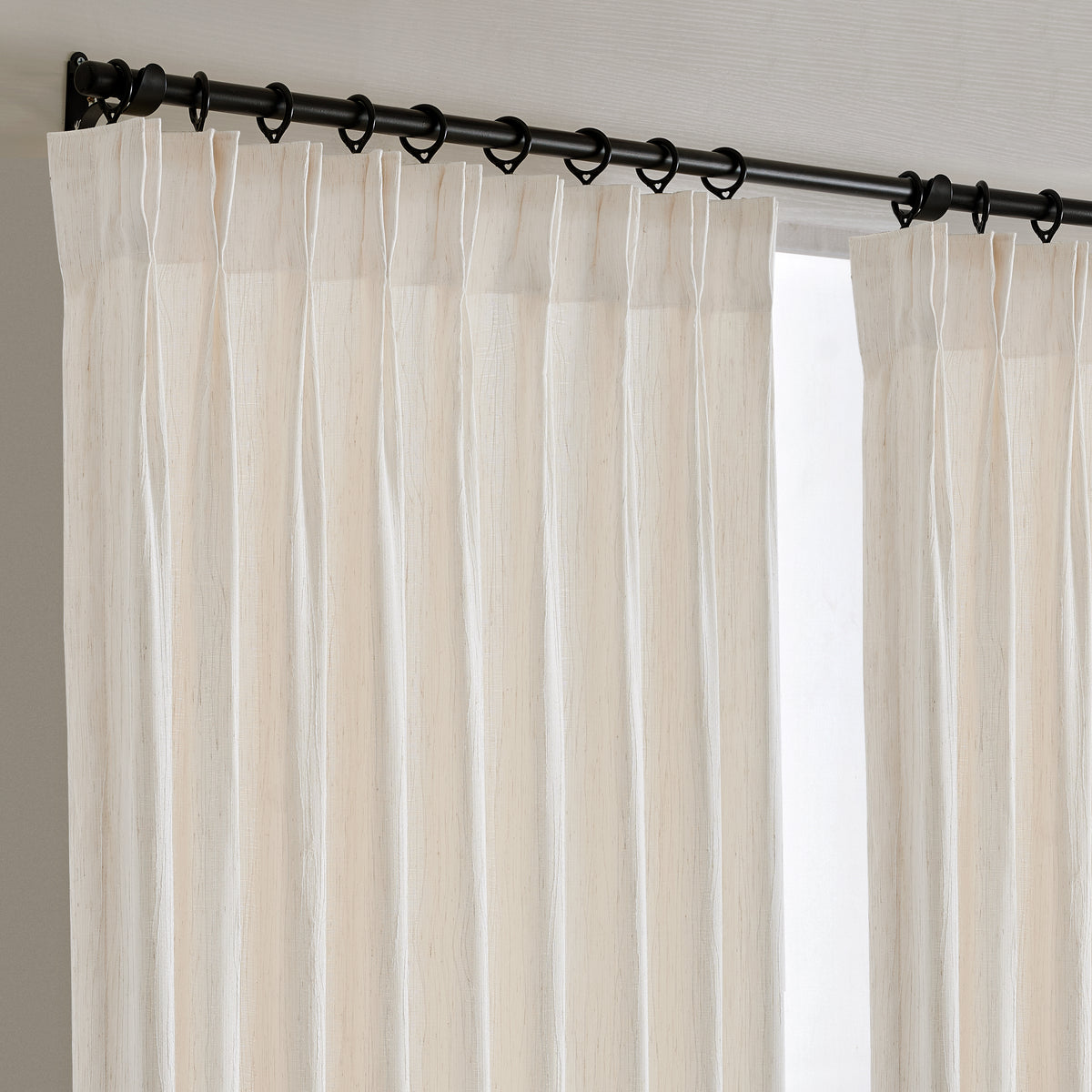 Odile Vine Sheer Curtains in Beige, hanging at the window