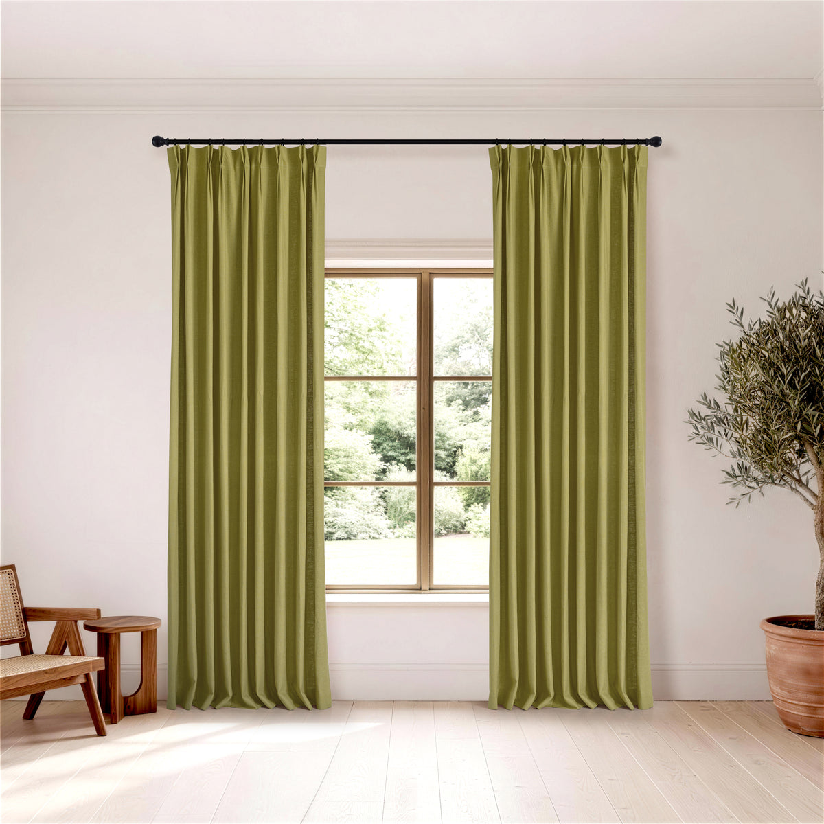 Edwina Linen-Cotton Curtains in Olive, hanging in a room