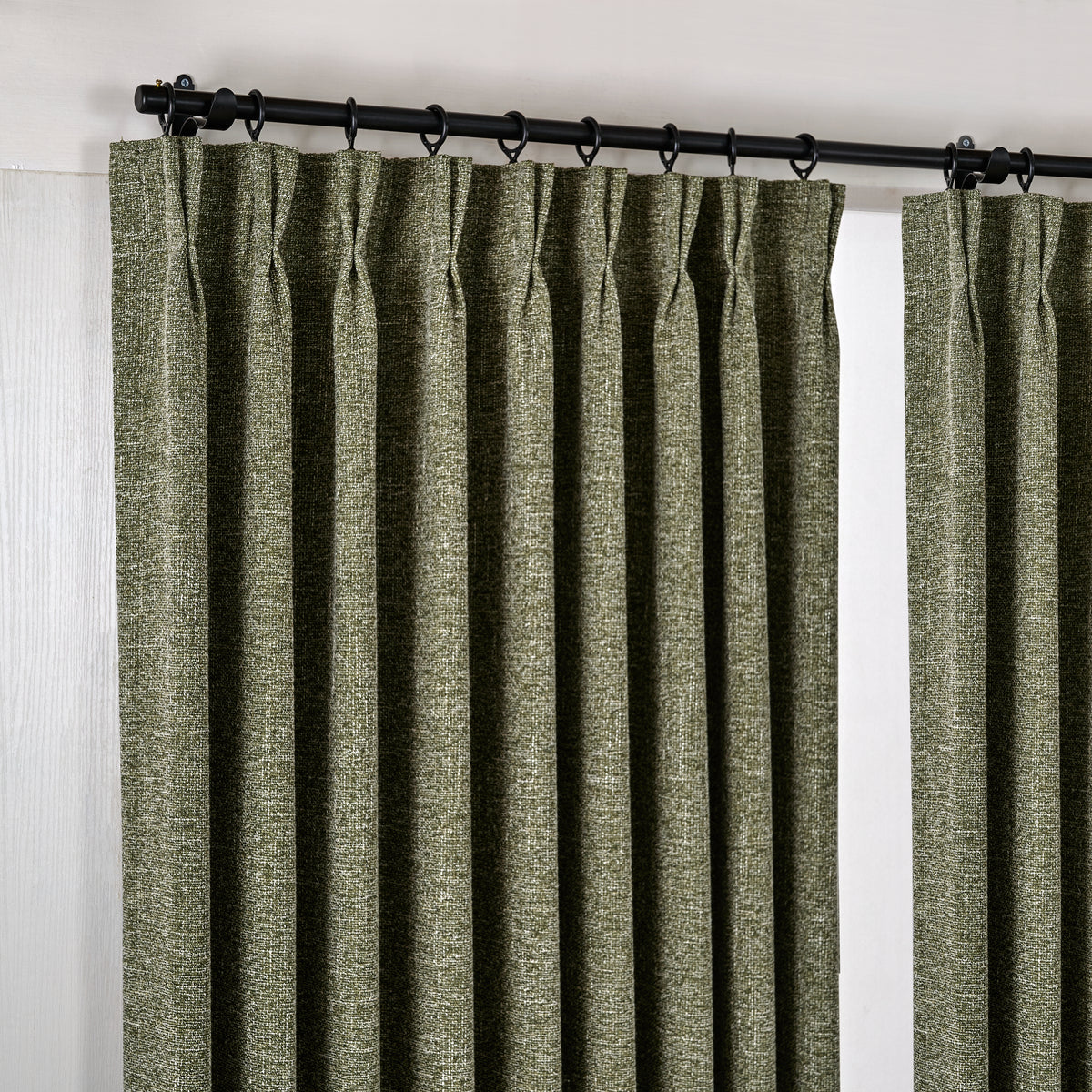Tamsin Melange Weave Blackout Curtains in Olive, hanging at the window