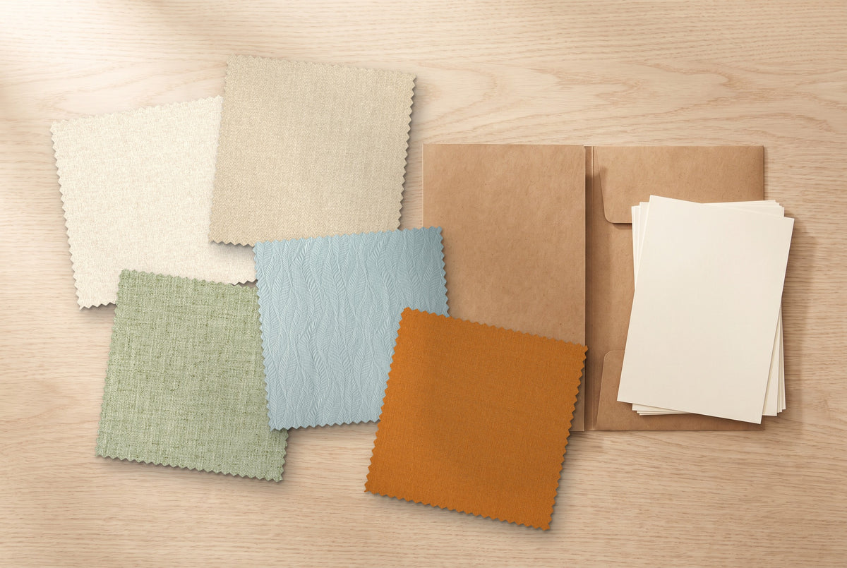 Five fabric swatches on a table beside a kraft folder: Ivory, Oat, Sage, Dusty Blue and Terracotta